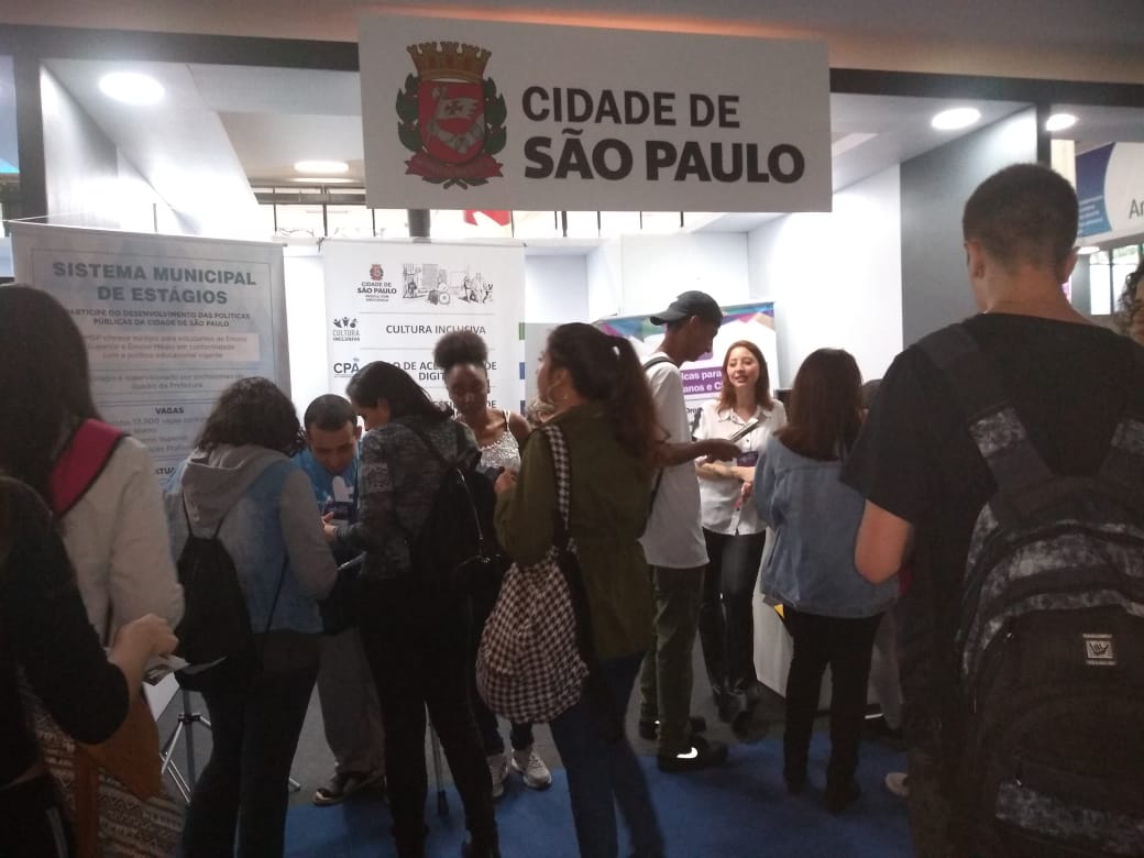 Foto da frente do estande da Prefeitura de São Paulo na Expo CIEE. Várias pessoas estão concentradas no local.